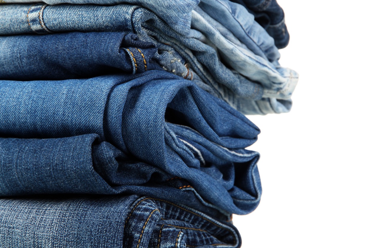 Lot of different blue jeans close-up isolated on white; Shutterstock ID 114997642; PO: aol; Job: production; Client: drone